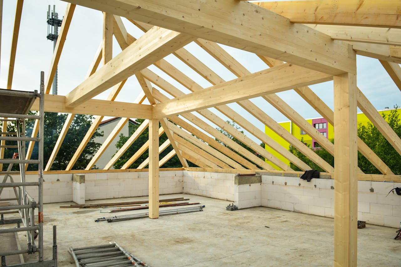 Wooden roof structure in progress with open sky view, ideal for construction themes.